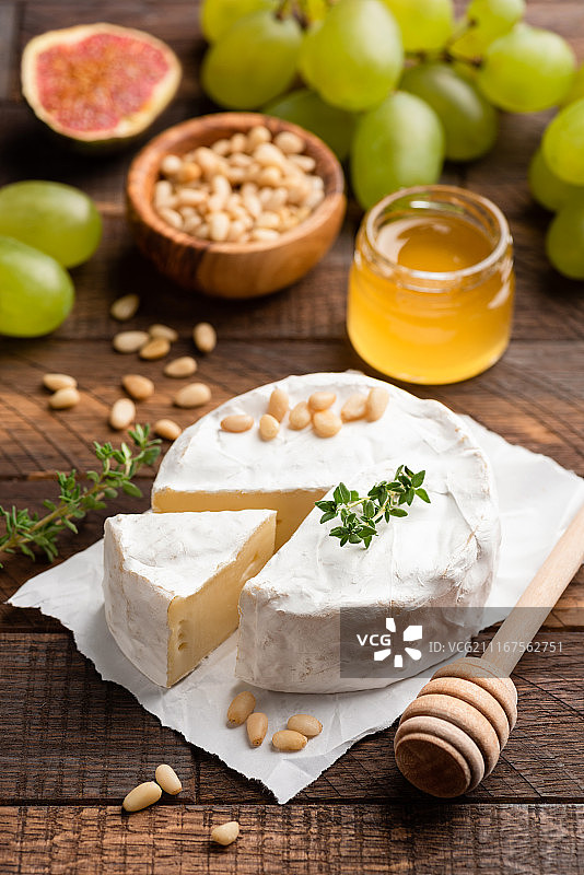 布里干酪或卡芒贝尔干酪配松子、无花果、蜂蜜和绿葡萄图片素材