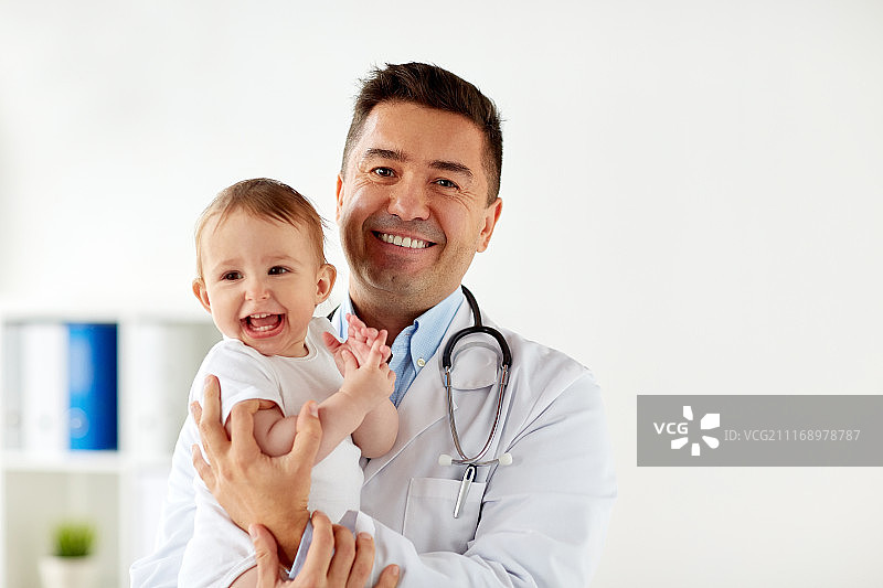 医学、保健、儿科和人的理念——快乐医生或儿科医生抱着婴儿在诊所进行医学检查。快乐的医生或儿科医生与婴儿在诊所图片素材