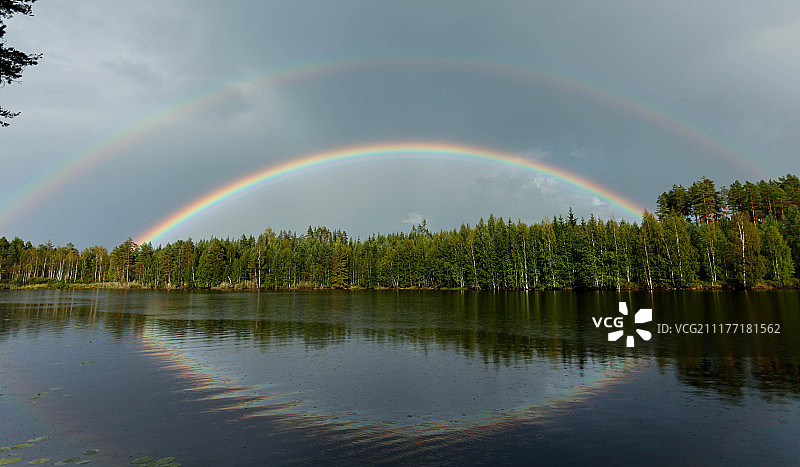 森林上的双虹反射在湖中图片素材