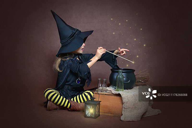 穿着女巫服装的女孩在做魔法药水图片素材