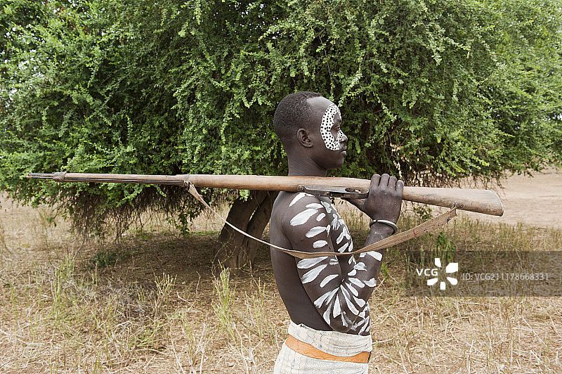 身体和面部的卡罗战士拿着步枪，奥莫河谷，埃塞俄比亚南部，非洲图片素材