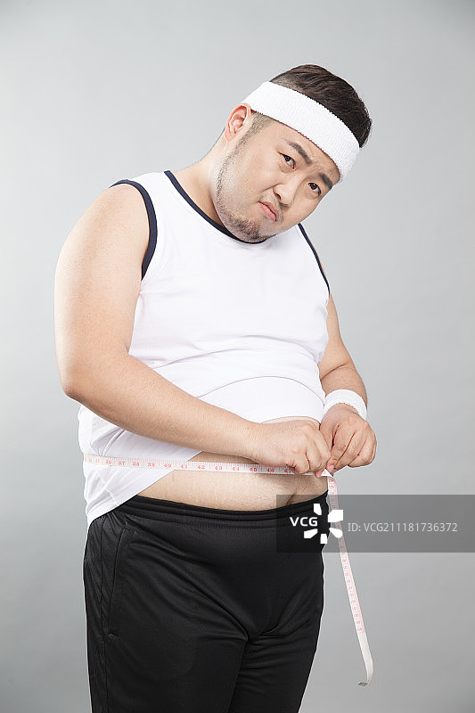 肥胖的青年男人称体重图片素材