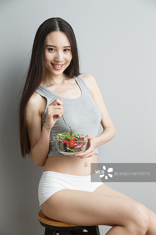 青年女人吃水果沙拉图片素材