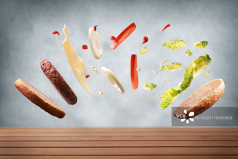 经典的牛肉汉堡漂浮在木头桌子和灰色的背景图片素材