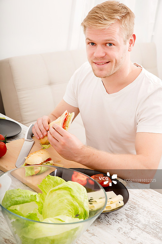 在家里吃三明治的年轻人图片素材