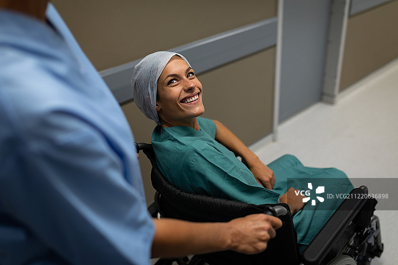 高视角的白种女性病人在轮椅上与白种女性外科医生在医院走廊交谈图片素材
