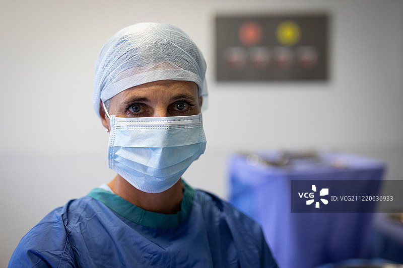 一位白种女外科医生戴着手术口罩看着手术室里的摄像机图片素材
