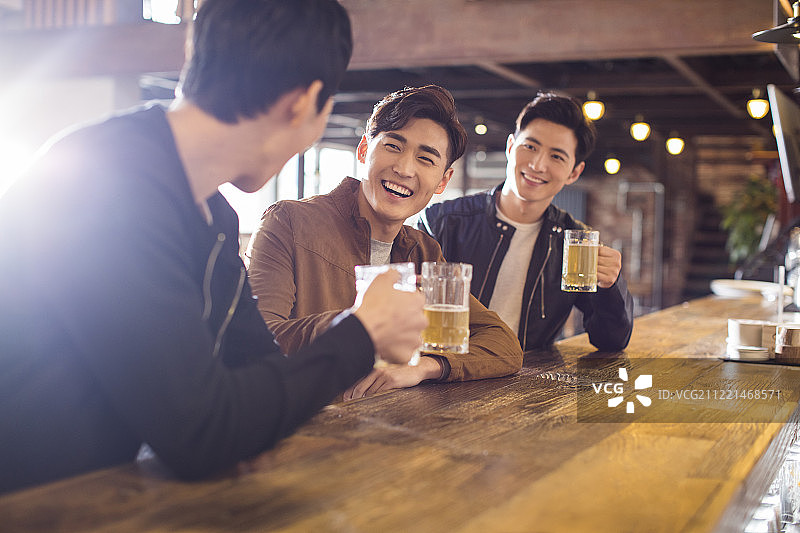 快乐的年轻男士在酒吧喝酒图片素材