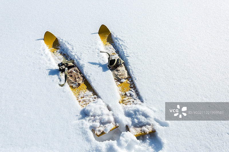 一对老式木制黄色滑雪板在白雪上图片素材