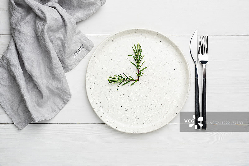 白色的盘子和餐具放在白色的木板上，食物背景图片素材