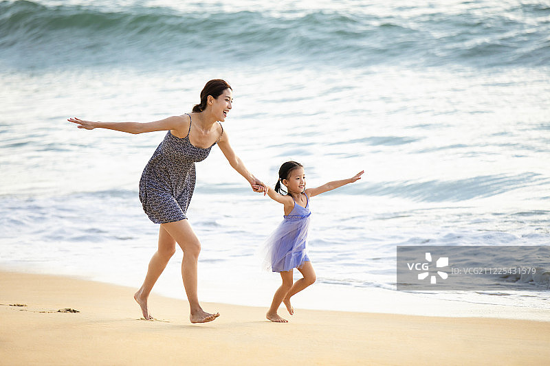 快乐的母女在沙滩上嬉戏图片素材