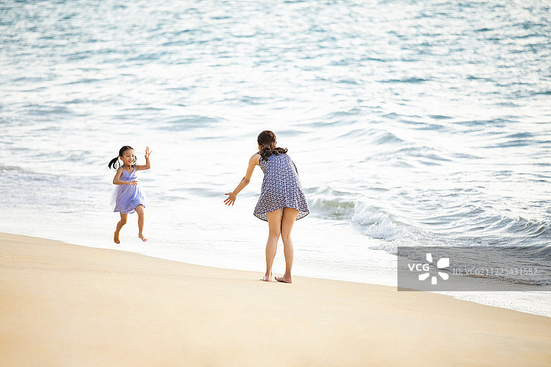 快乐的母女在沙滩上嬉戏图片素材