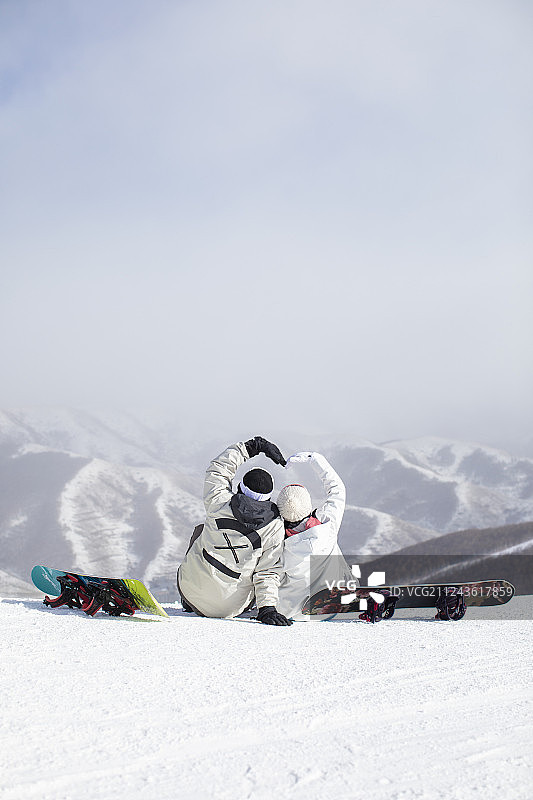 年轻情侣在滑雪场休息图片素材