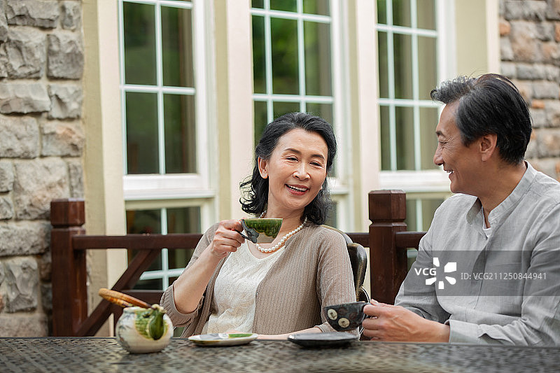 老年夫妇坐在院子里喝茶图片素材