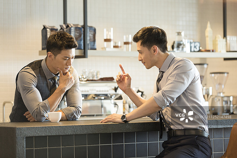 两个成功商务青年男子在公司茶水间吧台喝咖啡沟通讨论工作图片素材