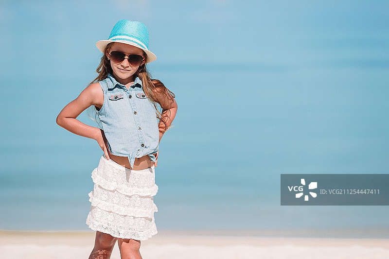 暑假期间可爱的小女孩在海滩上的肖像图片素材