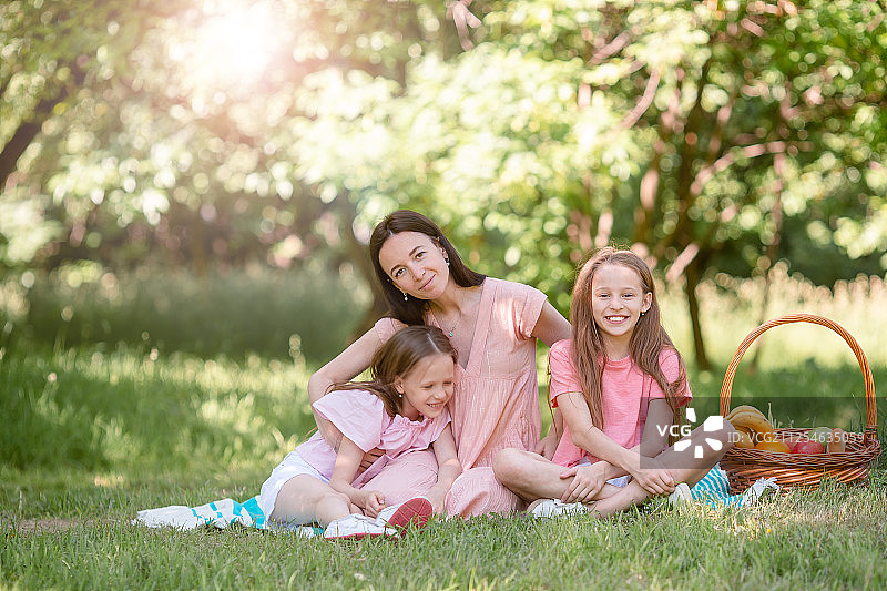 快乐的妈妈和小女儿们在湖边放松图片素材