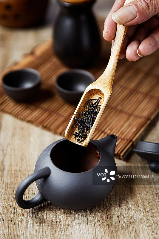 中国功夫茶用茶匙把茶叶倒入紫砂茶壶图片素材