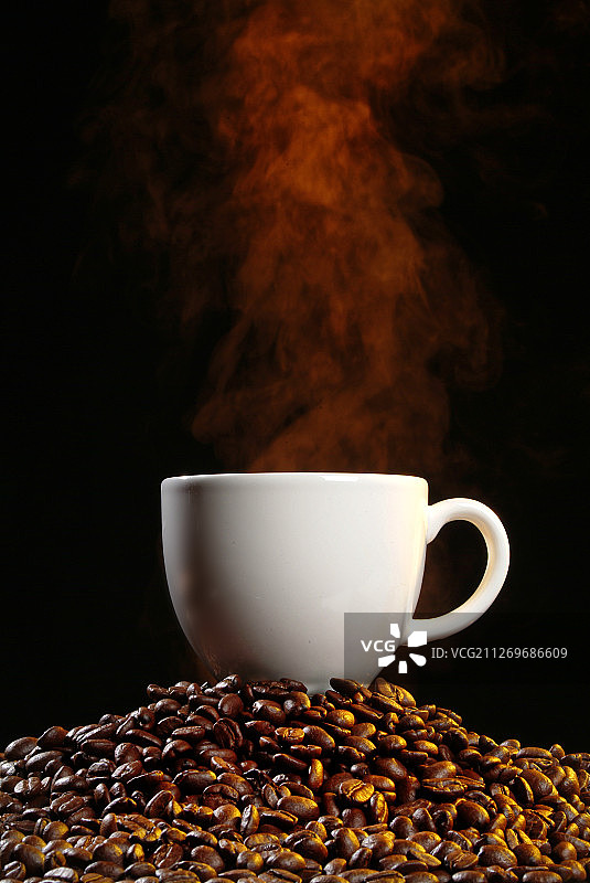 咖啡杯放在咖啡豆上图片素材