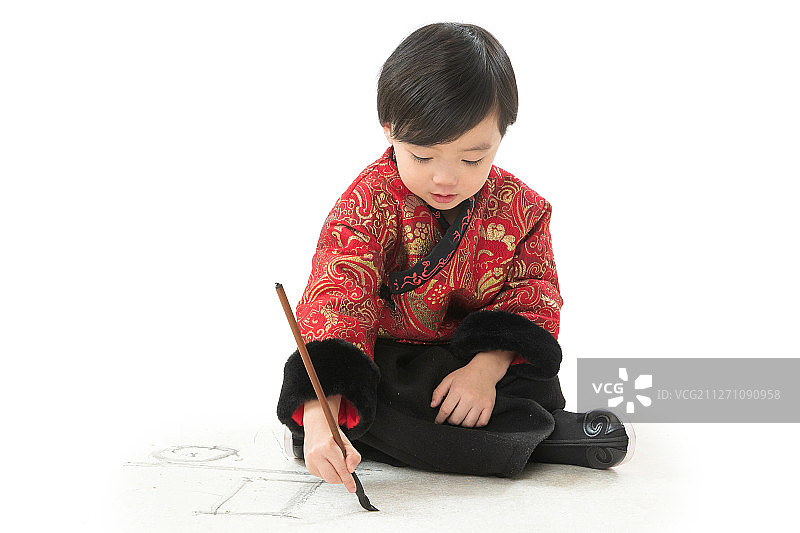 可爱的小男孩坐在地上画画图片素材