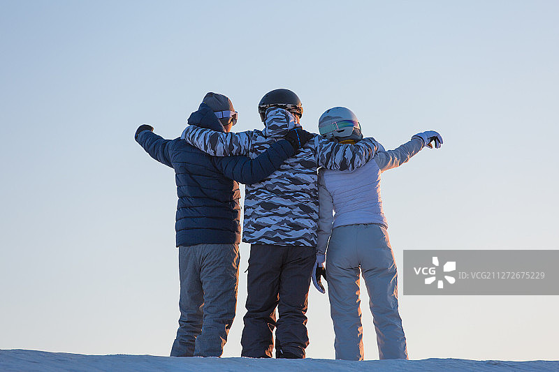 三个青年男女在户外滑雪 场搂在一起看风景图片素材