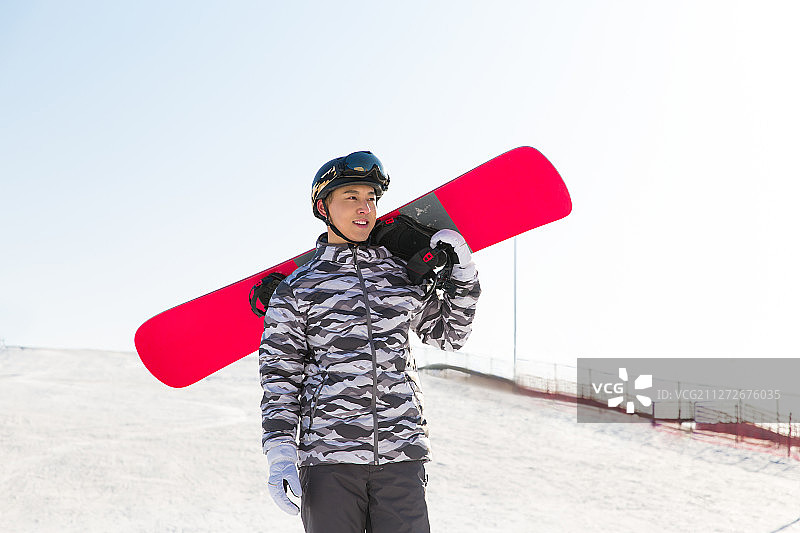 年轻男子在户外背着滑雪板准备滑雪肖像图片素材