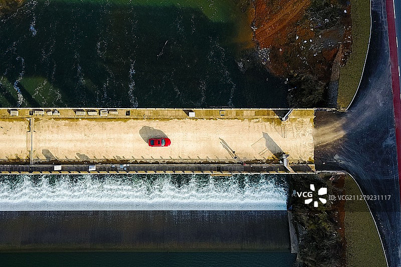 江西婺源一座小堤坝，一辆红色小轿车正好通过。图片素材