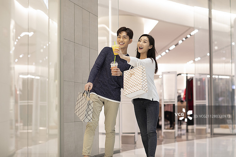 快乐的年轻情侣在商场购物图片素材