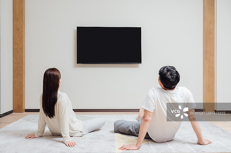 亚洲年轻情侣在家看电视图片素材