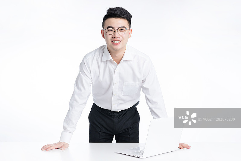一位亚洲年轻商务男士站在办公桌后面图片素材