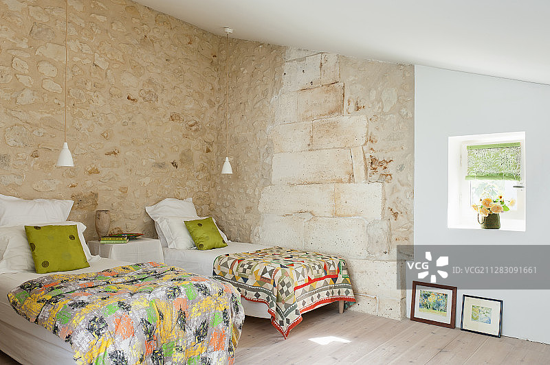 两张单人床在一间有着石墙的乡村卧室里图片素材