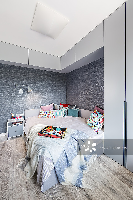 灰色的卧室，床上方有高高的壁挂式橱柜图片素材