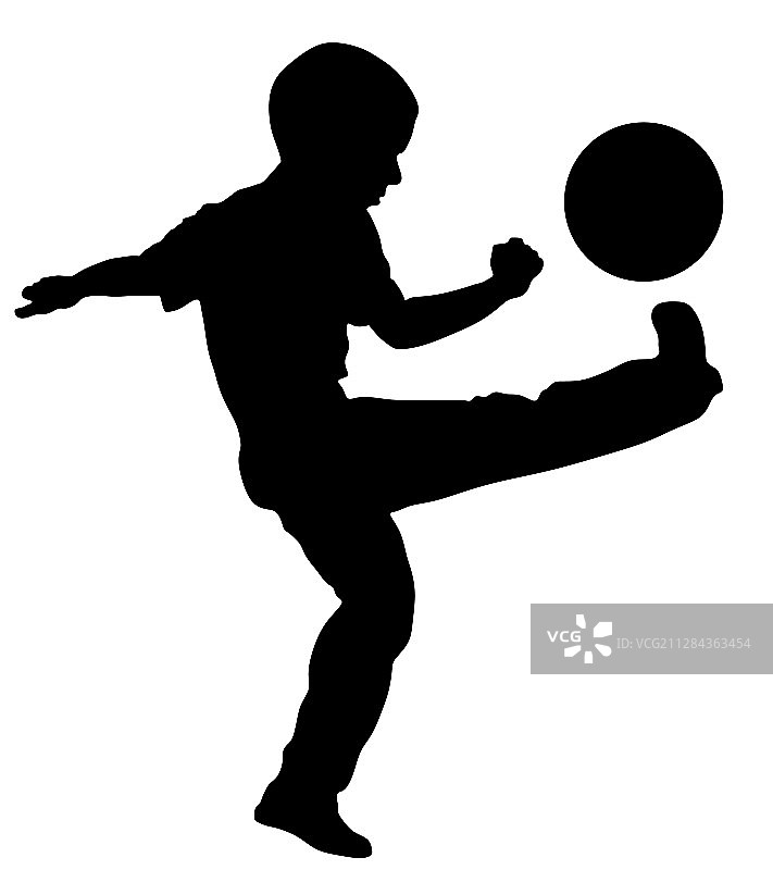 小男孩用球踢足球的剪影图片素材