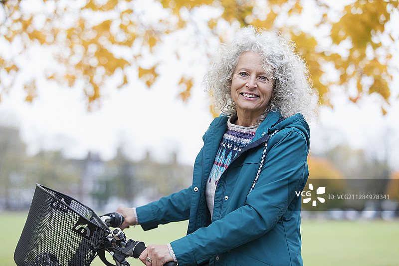 肖像自信，微笑的老年妇女骑在秋天的公园图片素材