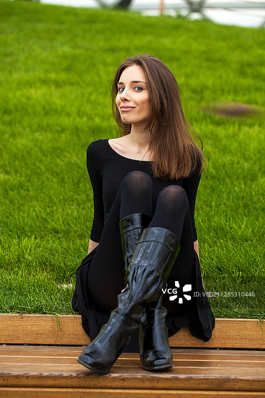 俄罗斯Pervomayskiy，一名年轻女子在长凳上摆姿势图片素材