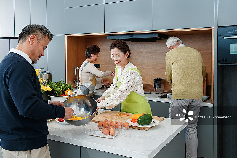 快乐的中老年人在厨房做饭图片素材