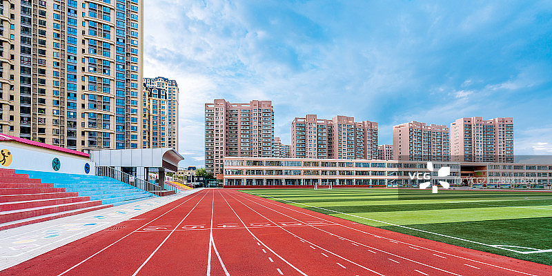 体育场的红色跑道和远处的高楼建筑图片素材
