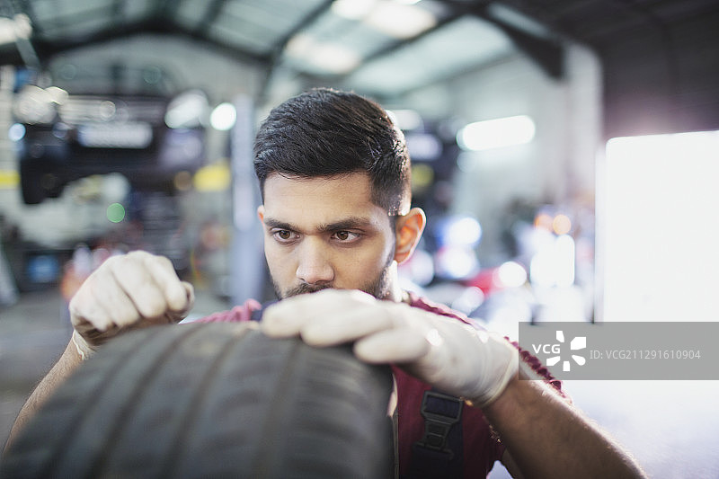 男性机械师在汽车修理厂检查轮胎图片素材