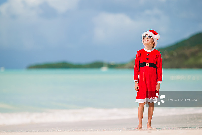 热带海滩上戴着圣诞帽的女孩图片素材