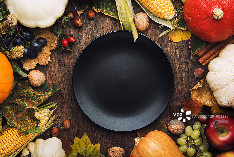 高角度的感恩节晚餐地点设置与秋天的，南瓜和坚果图片素材