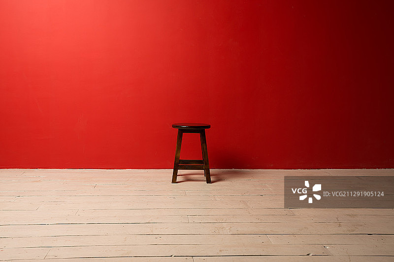 工作室拍摄的凳子在红色背景的木地板上图片素材