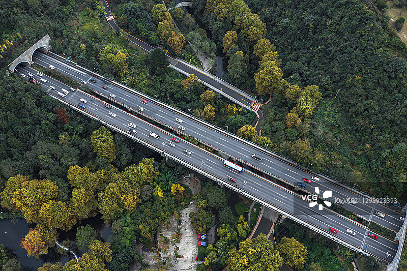 航拍贵州喀斯特地貌高山下森林里的高速公路图片素材