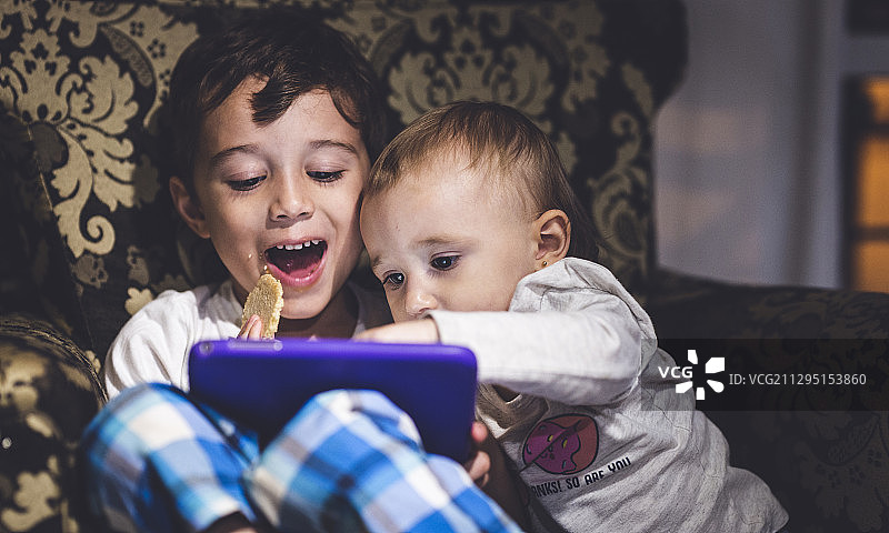快乐的兄弟姐妹的孩子使用数字平板电脑，波萨达斯，阿根廷图片素材