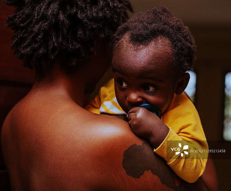 加纳特马，有胎记的黑人母亲将婴儿抱在肩上图片素材