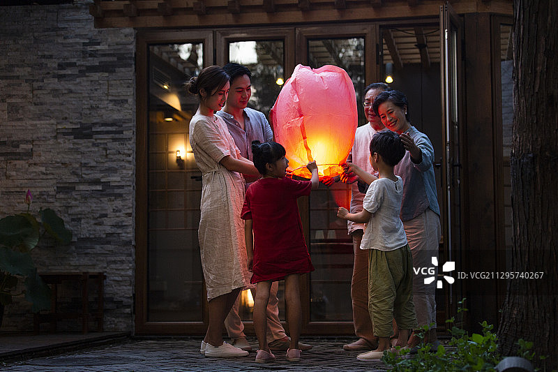 中秋节一家六口户外庭院放孔明灯图片素材