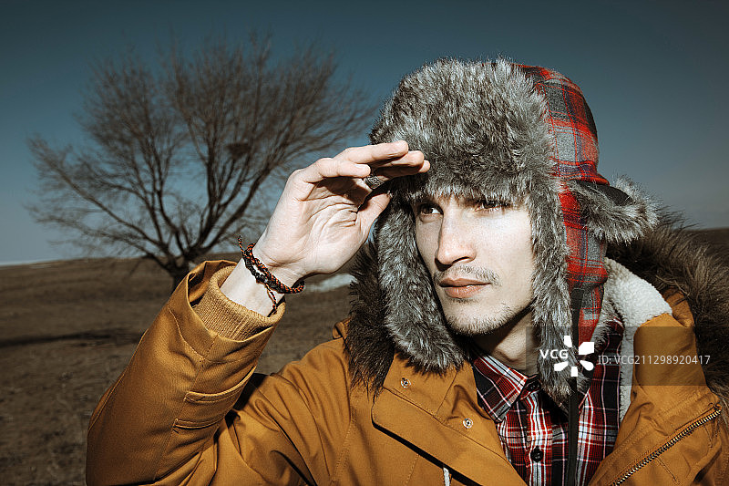 戴着猎人帽的男人在冬天的地形上图片素材