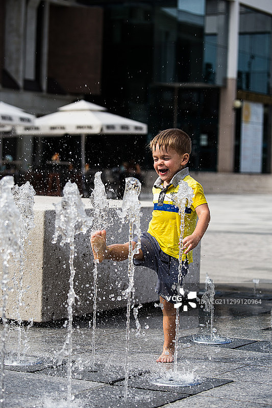 可爱的男孩在喷泉里玩耍，伊德里加，斯洛文尼亚图片素材