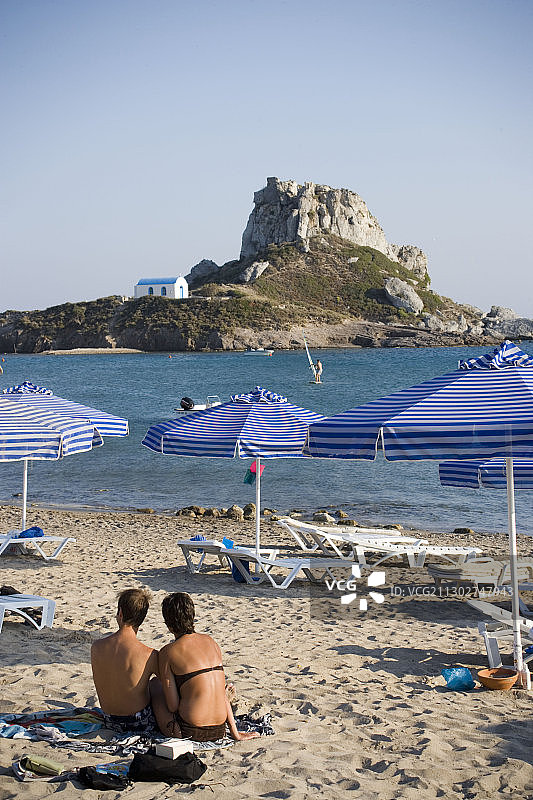 希腊科斯科法洛斯，人们在凯法洛斯海滩晒太阳，背景是圣尼古拉斯教堂图片素材