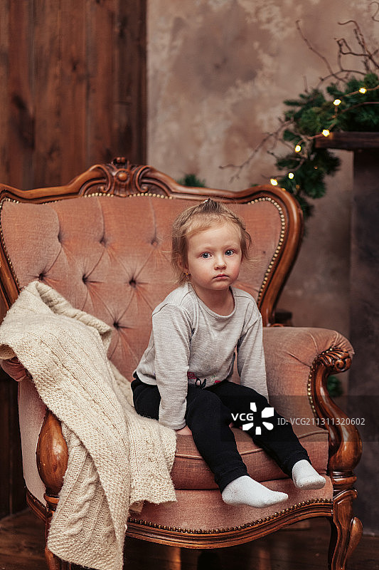 可爱的女孩坐在扶手椅上，俄罗斯图片素材