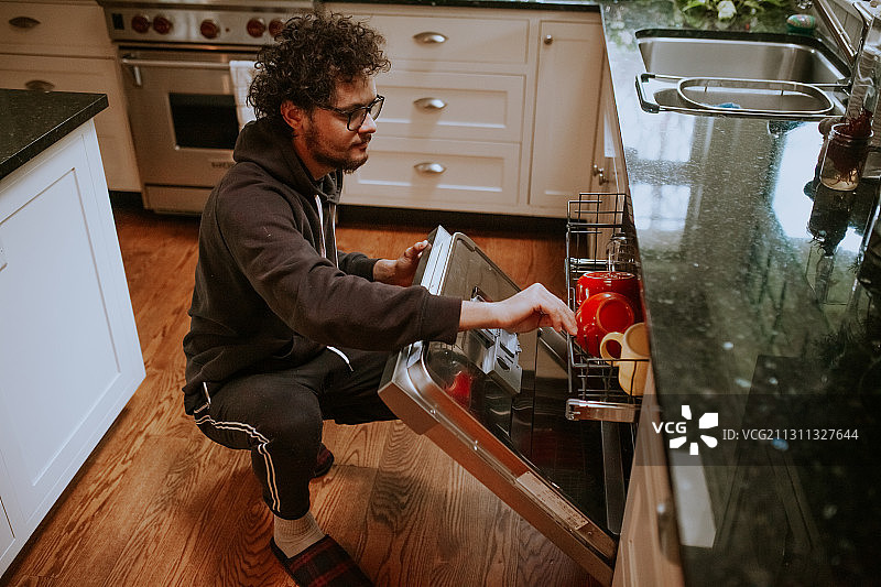 在家里装洗碗机的白人男子，维多利亚，不列颠哥伦比亚，加拿大图片素材